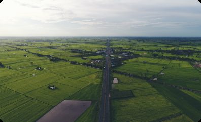Aerial view of farmland and a straight road corridor