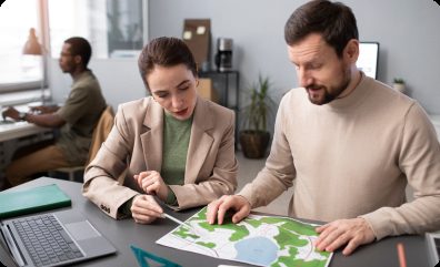 Two professionals reviewing a printed map at a desk